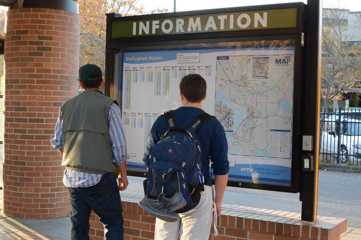 Riders check bus schedules at the Whatcom Transportation Authority’s downtown Bellingham terminal on Thursday, Oct. 18, 2018.