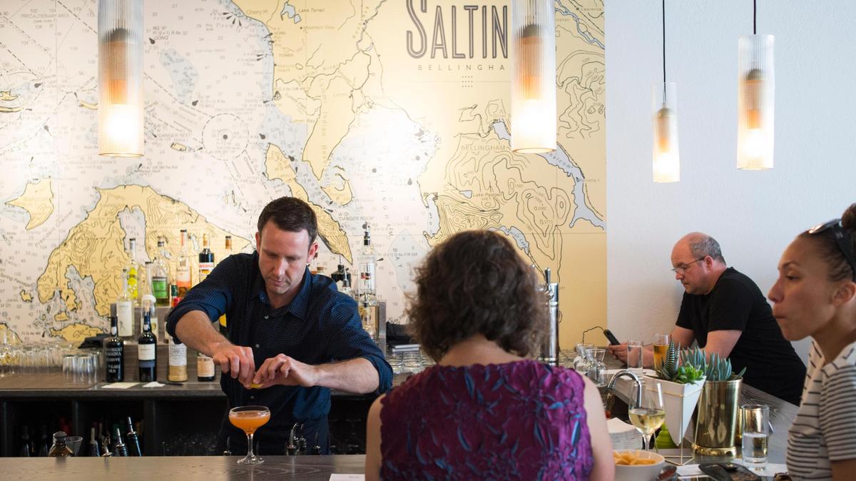 Luke Shifflette, left, makes a drink at Saltine in Bellingham. The restaurant is among recent downtown Bellingham restaurant/bar/cafe openings that include El Capitan’s, Big Love Juice, Black Sheep and Wild Oat Bakery.
