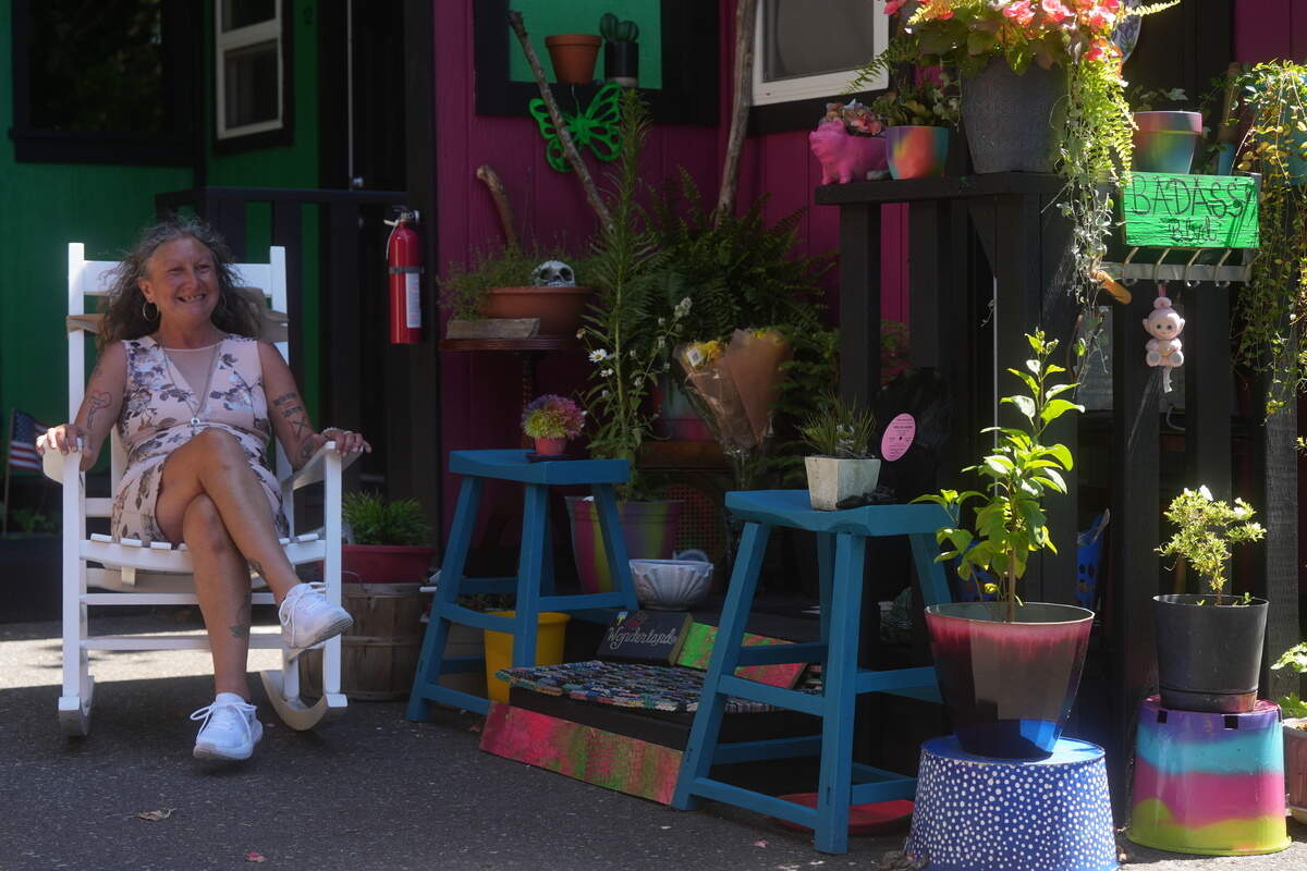 Desiree Rodriguez sits in a rocking chair in front of her unit at the North Haven tiny home village on July 7. Rodriguez was unhoused before moving into North Haven.