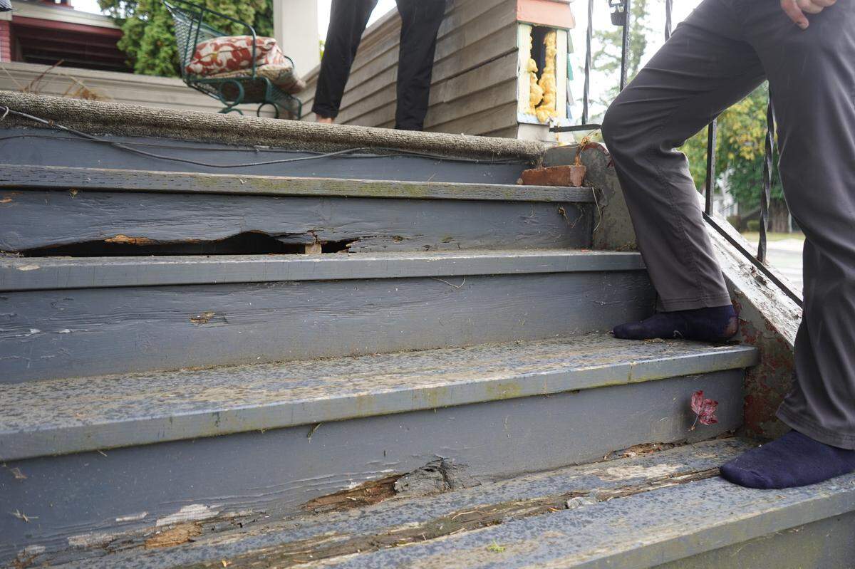 Aidan Hersh stands outside on the broken porch stairs at 1210 Ellis St. in 2023.