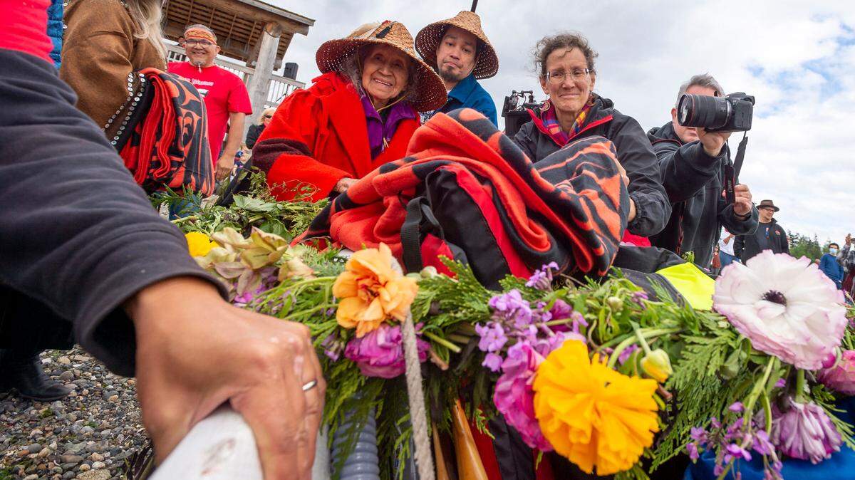 Lummi Nation elders Lutie Hillaire, center left, and Raymond Hillaire gift a blanket to members of the Skul-itch (Octopus) Canoe Family from Tacoma during the Gathering of the Eagles canoe landing celebration at the Lummi Stommish grounds on Friday afternoon May 27, 2022, on the Lummi Reservation in Whatcom County, Wash.