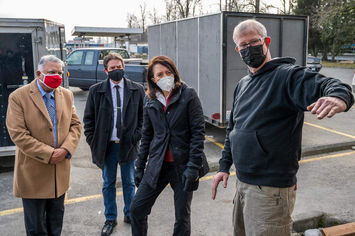 Whatcom County Executive Satpal Sidhu, left, Sumas Mayor Bruce Bosch and U.S. Senator Maria Cantwell listen as David Wynne describes flood damage at Bob’s Burger & Brew on Tuesday, Jan. 25, in Sumas.