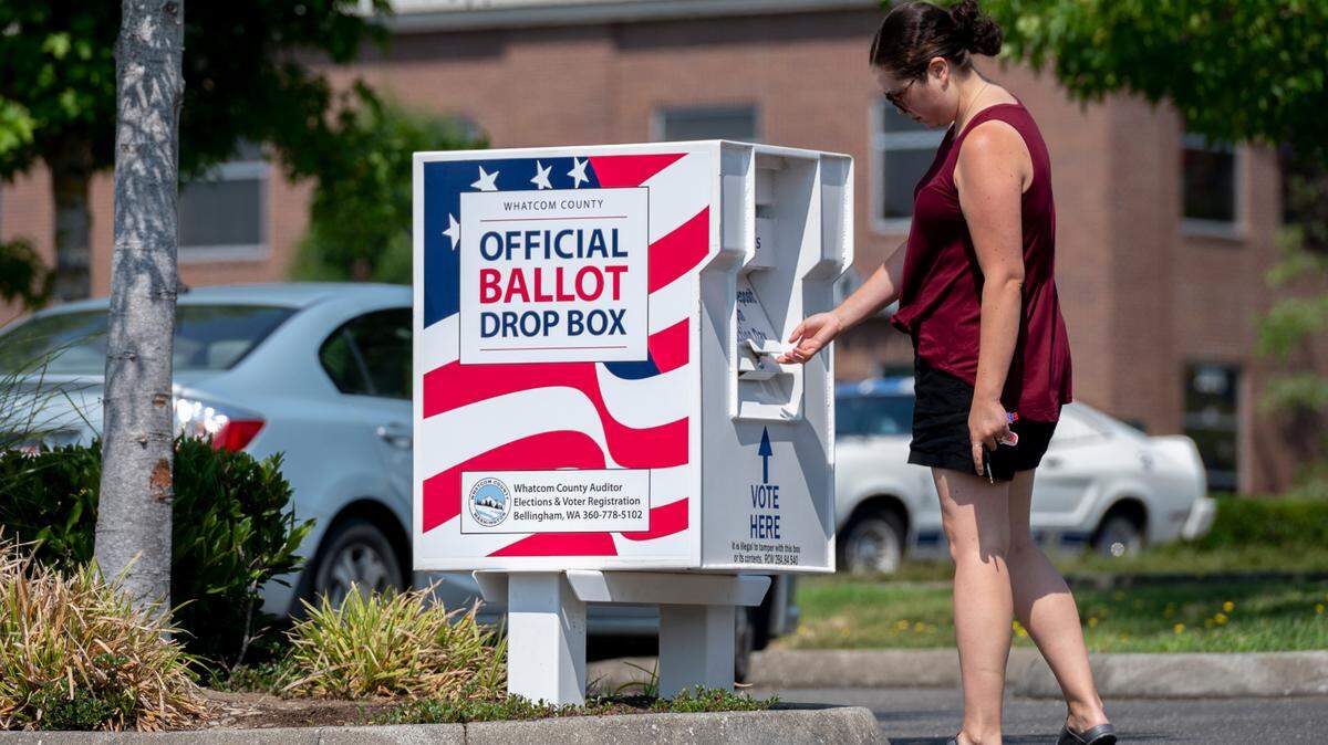 A woman drops a ballot into the new ballot drop box in Barkley Village in 2021.