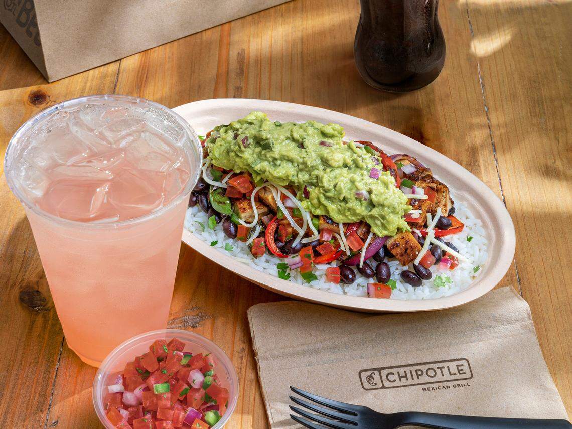 A Chipotle meal with a burrito bowl, drink and pico de gallo.