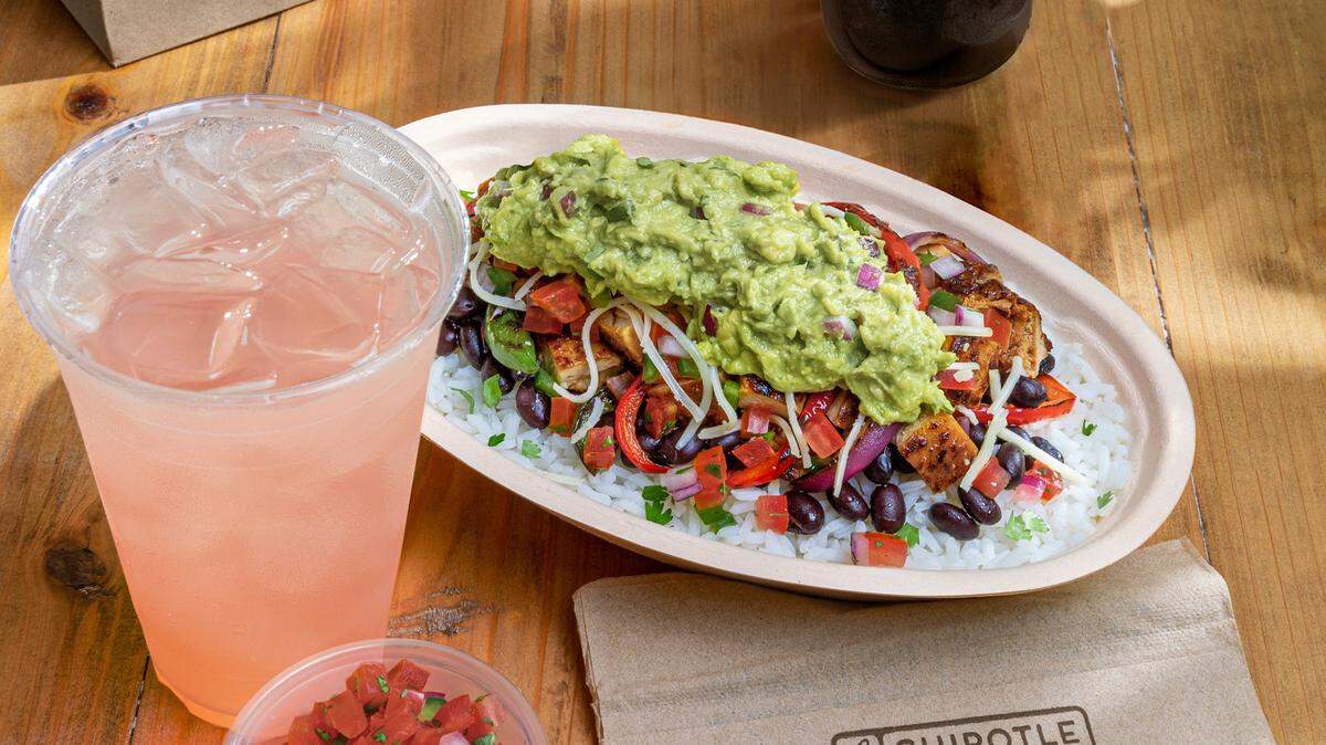 A Chipotle meal with a burrito bowl, drink and pico de gallo .