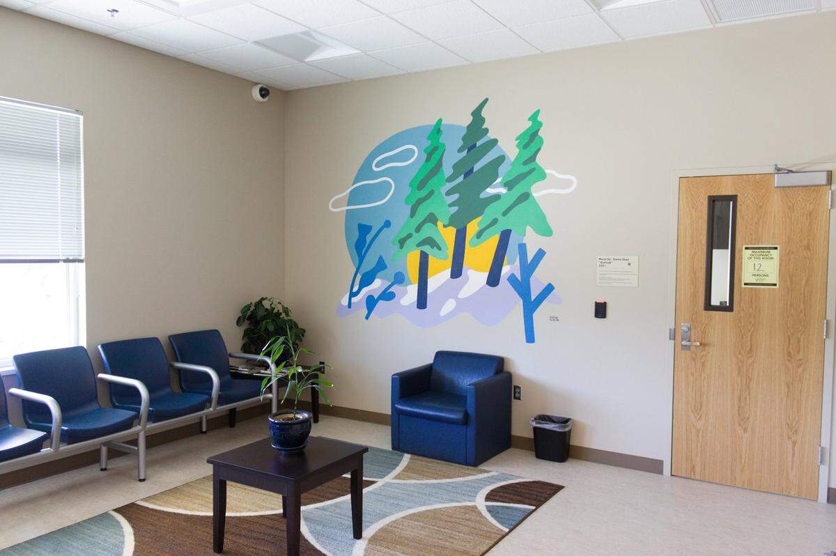 A mural inside a sitting area at the Whatcom Triage Center depicts trees and a blue sky in Bellingham.