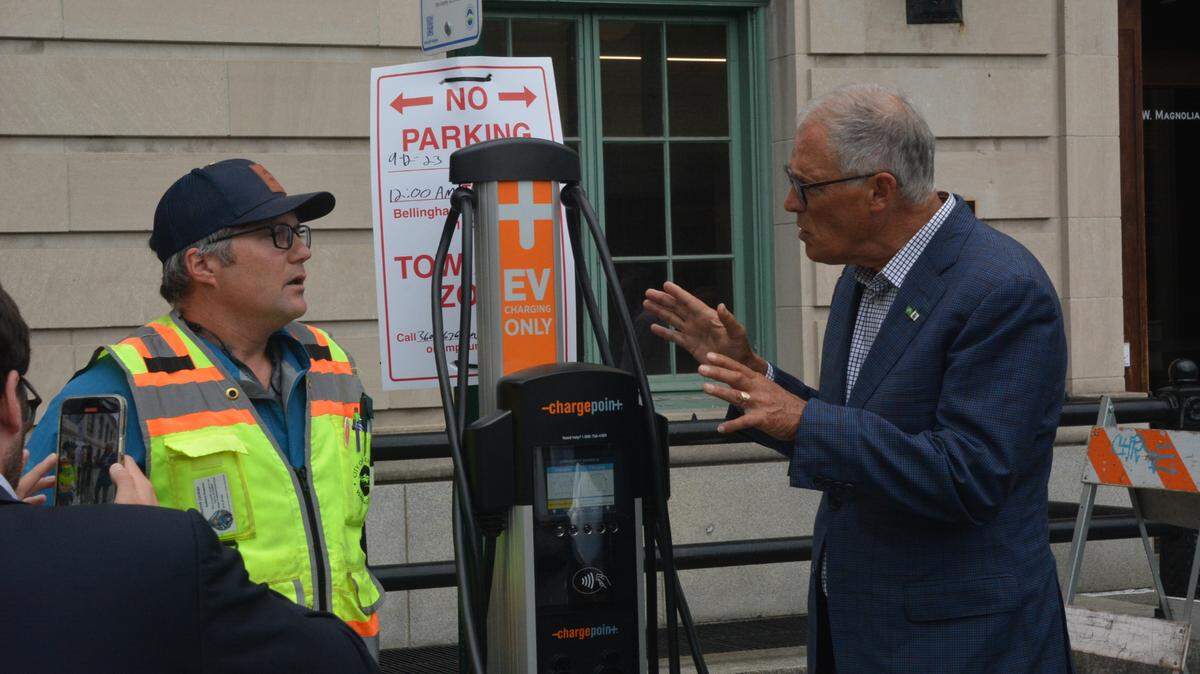 Washington state Gov. Jay Inslee, right, chats with Freeman Anthony, a project engineer in the Bellingham Public Works Department, on Tuesday. Inslee was visiting Whatcom County to see several local renewable energy projects that were funded through the Climate Commitment Act and other sources.