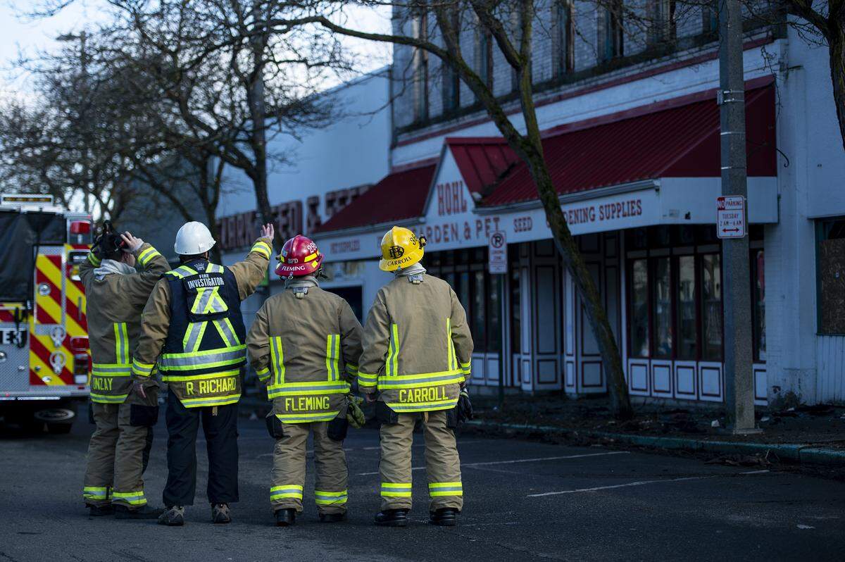 Fire Marshal Ron Richard gestures to the part of the Hohl Seed & Feed building where construction workers saw smoldering on Wednesday in Bellingham. “It was smoldering slightly in the framing of one of the buildings,” Richard said.