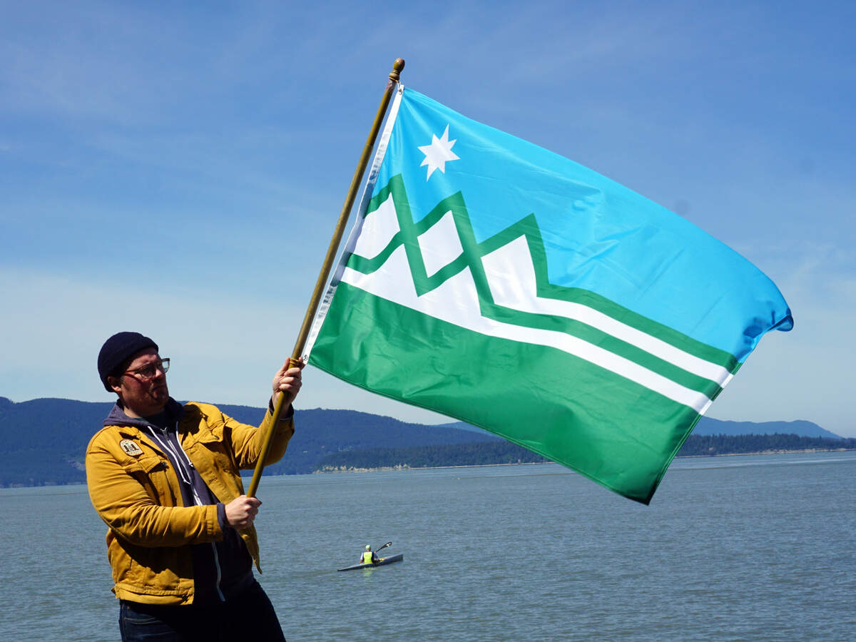 Bellingham designer Bradley Lockhart holds the flag that he proposes to replace the Washington state flag.