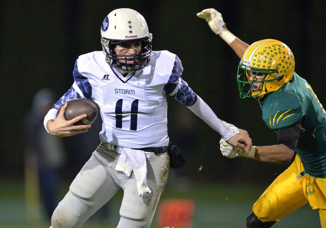 Squalicum’s Clark Hazlett is held by his sleeve by Lynden’s Jalani Phelps as he tries to escape the tackle in 2013. Hazlett played quarterback for the Storm from 2011-13 before transferring to Lynden for his senior season.