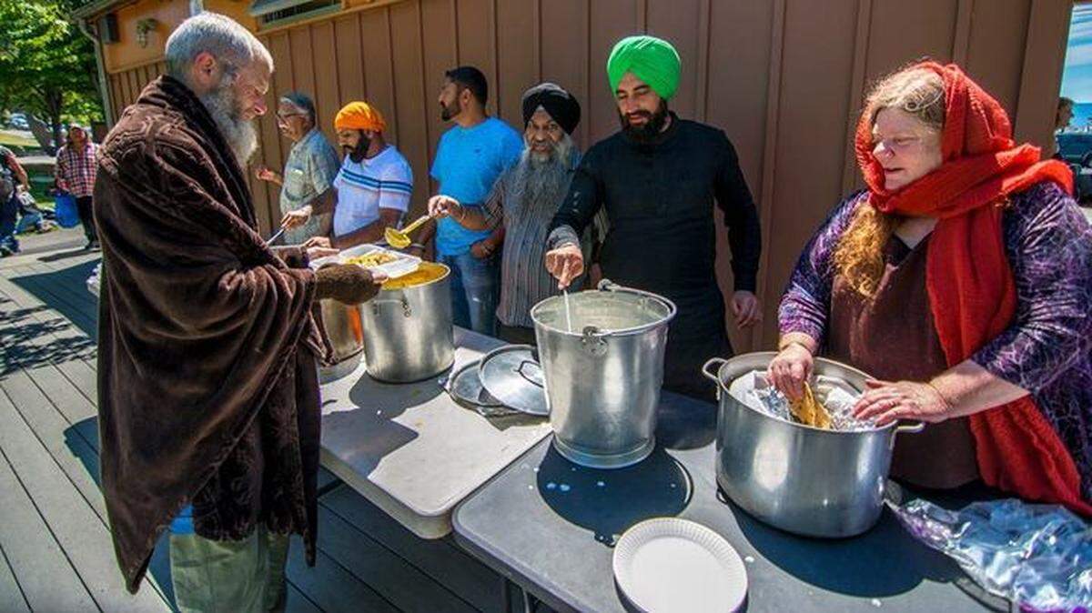 Volunteers of the Chardi Kala Project serving food to unhoused people in Bellingham at the Maritime Heritage Park in 2018.