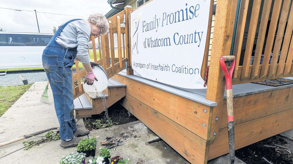 Interfaith Coalition of Whatcom County volunteer Lisa Blum of Bellingham waters freshly planted flowers as she helps finish the landscaping around the new Family Promise Day Center on Deemer Road in Bellingham