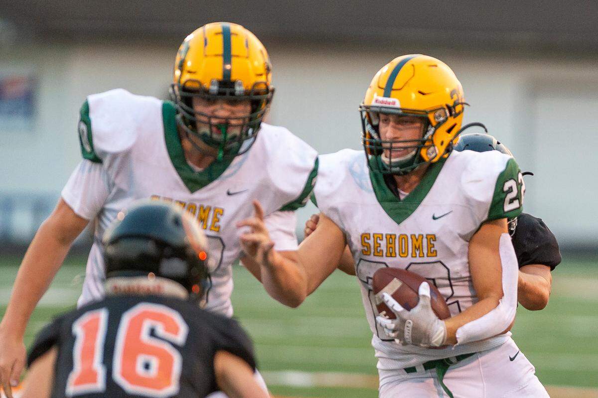Sehome running back Tommy Funk (22), right, looks for an opening as offensive lineman Coleton Heinze (70) prepares to block Blaine defensive back Jesse Deming to make a short gain during the first quarter on Friday evening, Sept. 9, at Blaine High School. Funk’s three touchdowns and 178 yards rushing helped the Mariners to remain undefeated on the field with an impressive 31-7 win over Burlington-Edison Friday, Sept. 23.