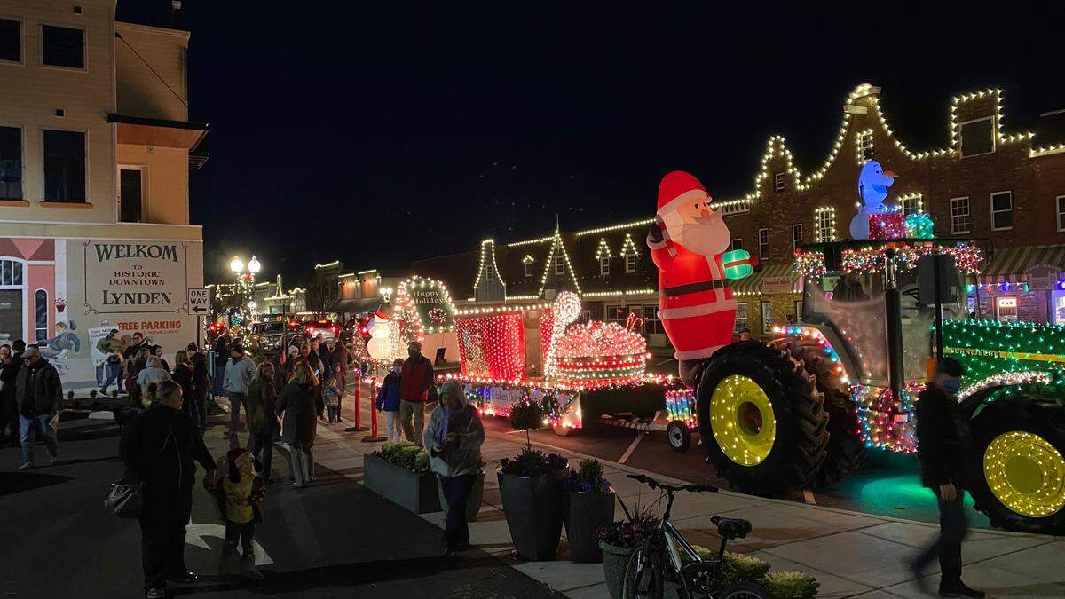 People walk down Front Street during the Northwest Lighted Christmas Parade on Saturday, Dec. 5, 2020, in Lynden, Wash.