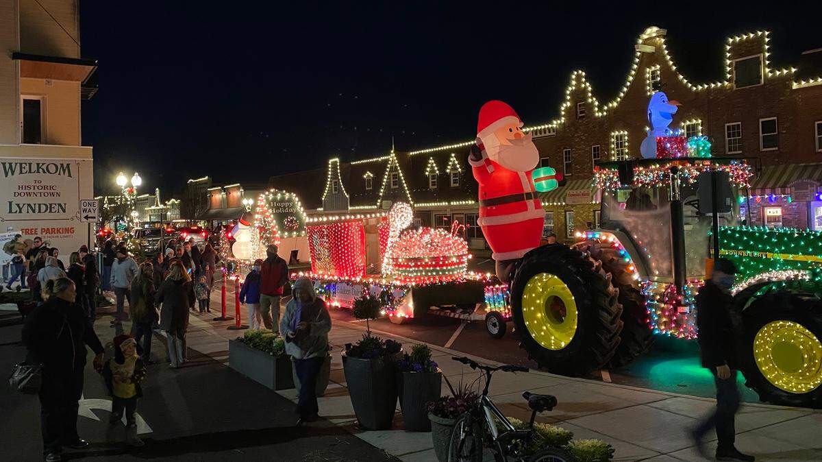 People walk down Front Street during the Northwest Lighted Christmas Parade on Saturday, Dec. 5, 2020, in Lynden, Wash.
