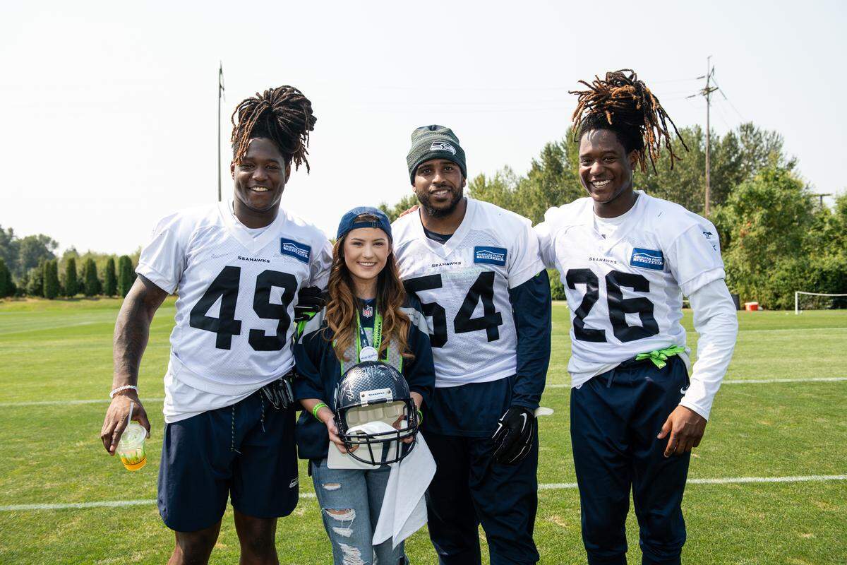 Seattle Seahawks linebackers Shaquem Griffin (49) and Bobby Wagner (54) and defensive back Shaquill Griffin (26) spend time with 17-year-old Amber Louden, a senior at Squalicum High, during a Make A Wish visit Aug. 8 at the Seahawks’ training facility in Renton.