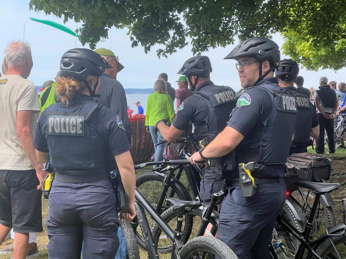 Bellingham Police officers on a bicycle patrol watch the finish line of the Ski to Sea race at Marine Park in Bellingham, Wash., on May 25, 2025.