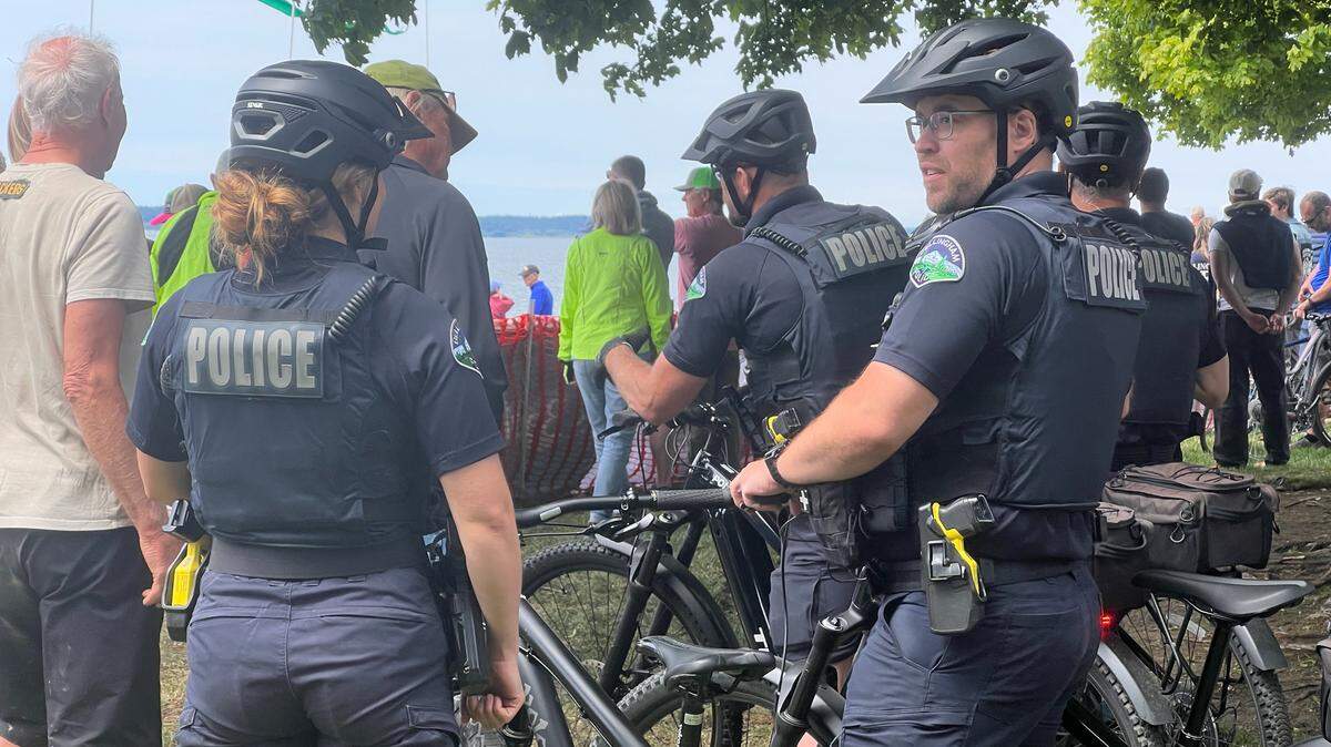 Bellingham Police officers on a bicycle patrol watch the finish line of the Ski to Sea race at Marine Park in May 25.