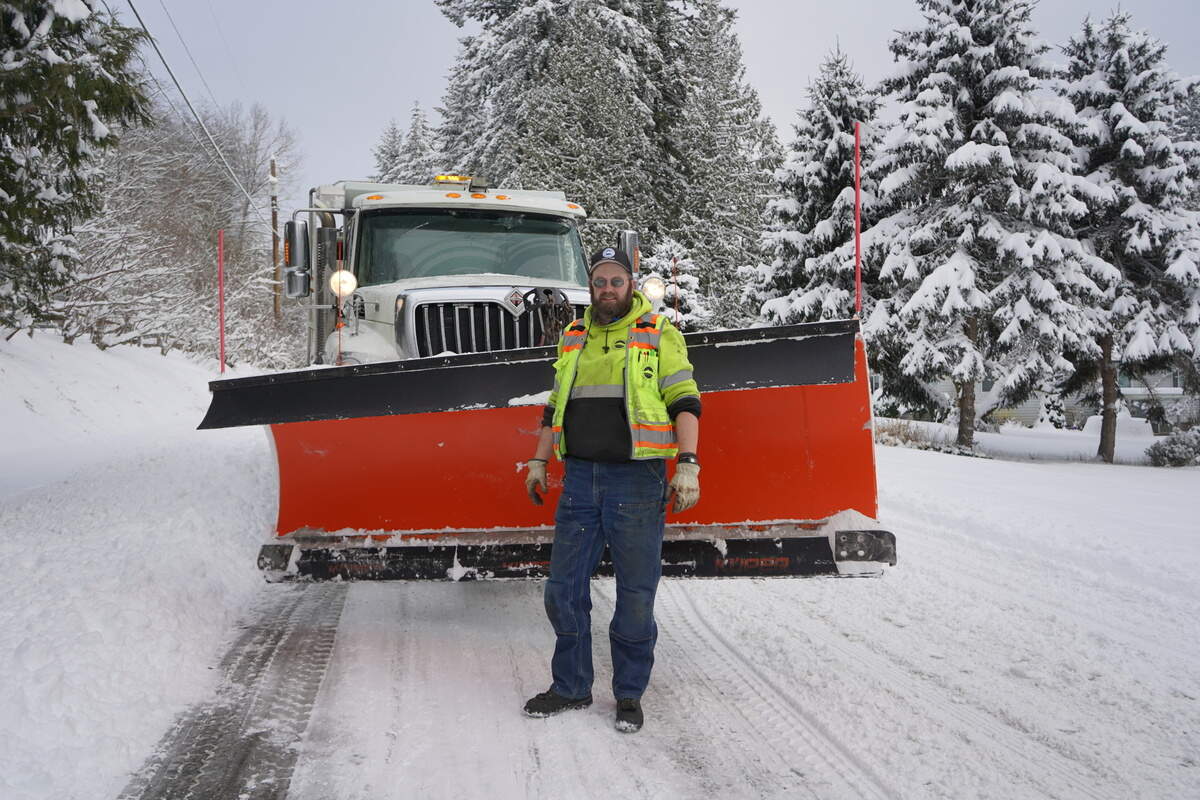 Snow plow operator Jess Herring stands in front of one of the city’s snow plow trucks Tuesday, Dec. 20, on Old Samish Road in Bellingham.