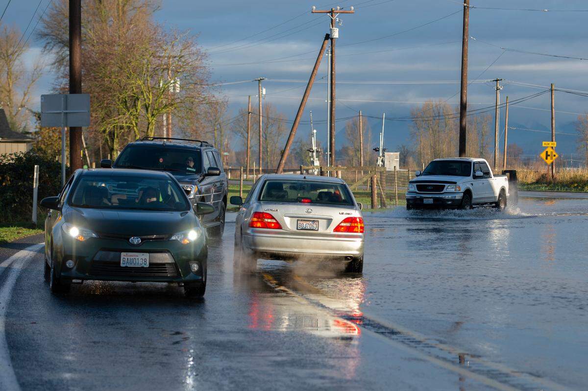Cars pass over Highway 9 near Alm Road during flooding on Monday, Nov. 29, 2021, in Everson, Wash. Another “atmospheric river” storm is expected to hit the area Monday night.