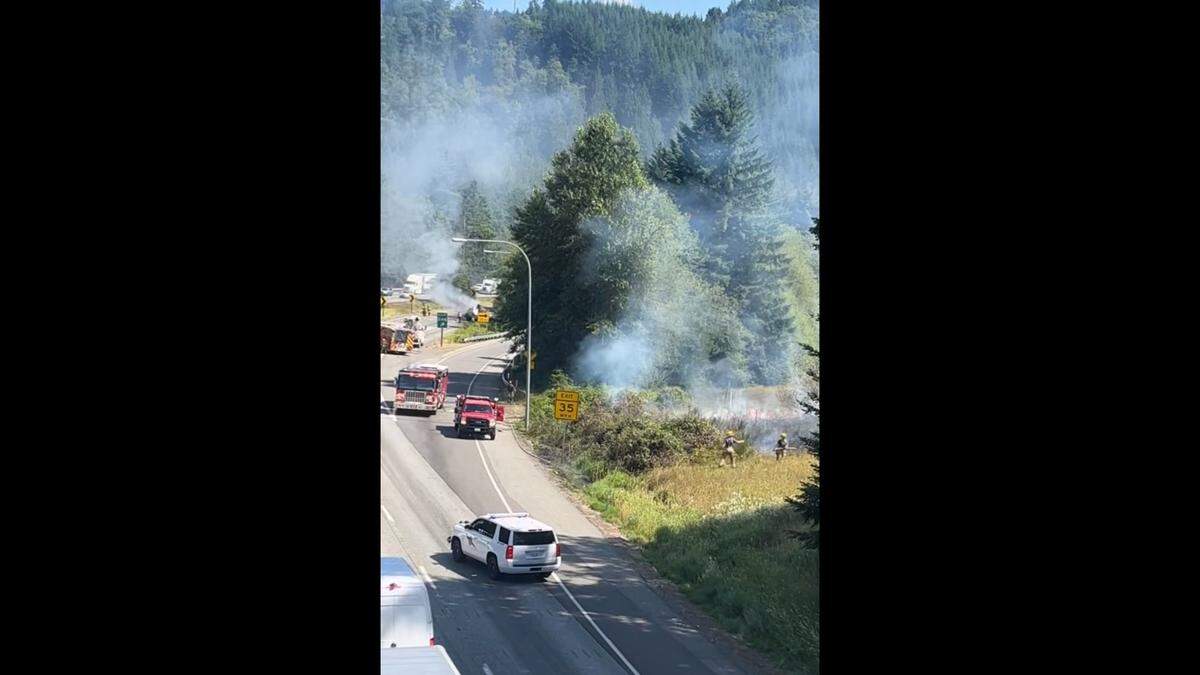 Fire crews fight a roadside brush fire along I-5 south of Bellingham on July 27, 2023.