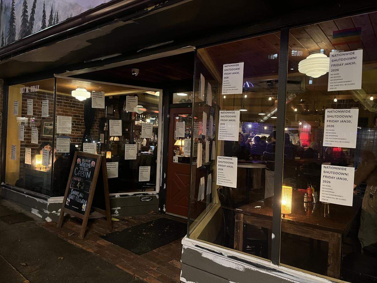 More than two dozen signs were posted at the Cabin Tavern in Bellingham, indicating that the bar and restaurant will participate in a nationwide shutdown of businesses and schools Friday, Jan. 30 to protest raids and the killing of civilians by Immigration and Customs Enforcement (ICE) agents.