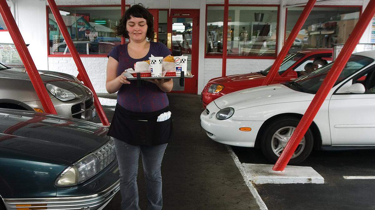 A server carries a tray of food to a customer at Boomer’s Drive-In in 2007.