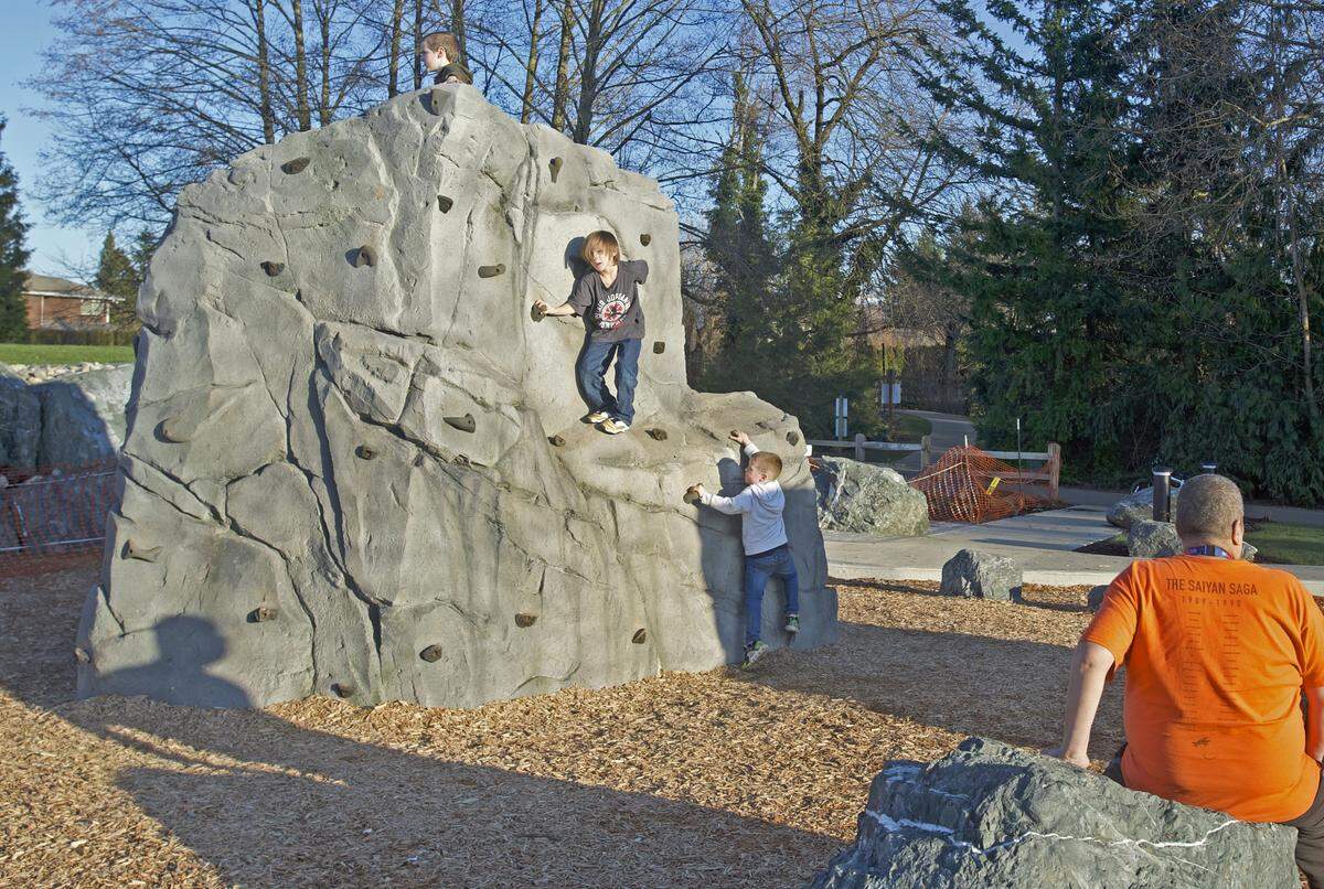 Children play on man-made boulders at Bender Fields in Lynden on Thursday.