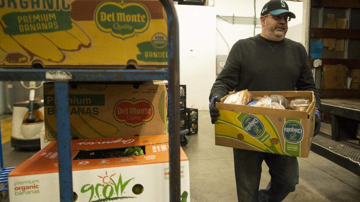 Bill Pearsall, a warehouse assistant and truck driver, unloads boxes of perishable foods from a truck at the Bellingham Food Bank in 2019.