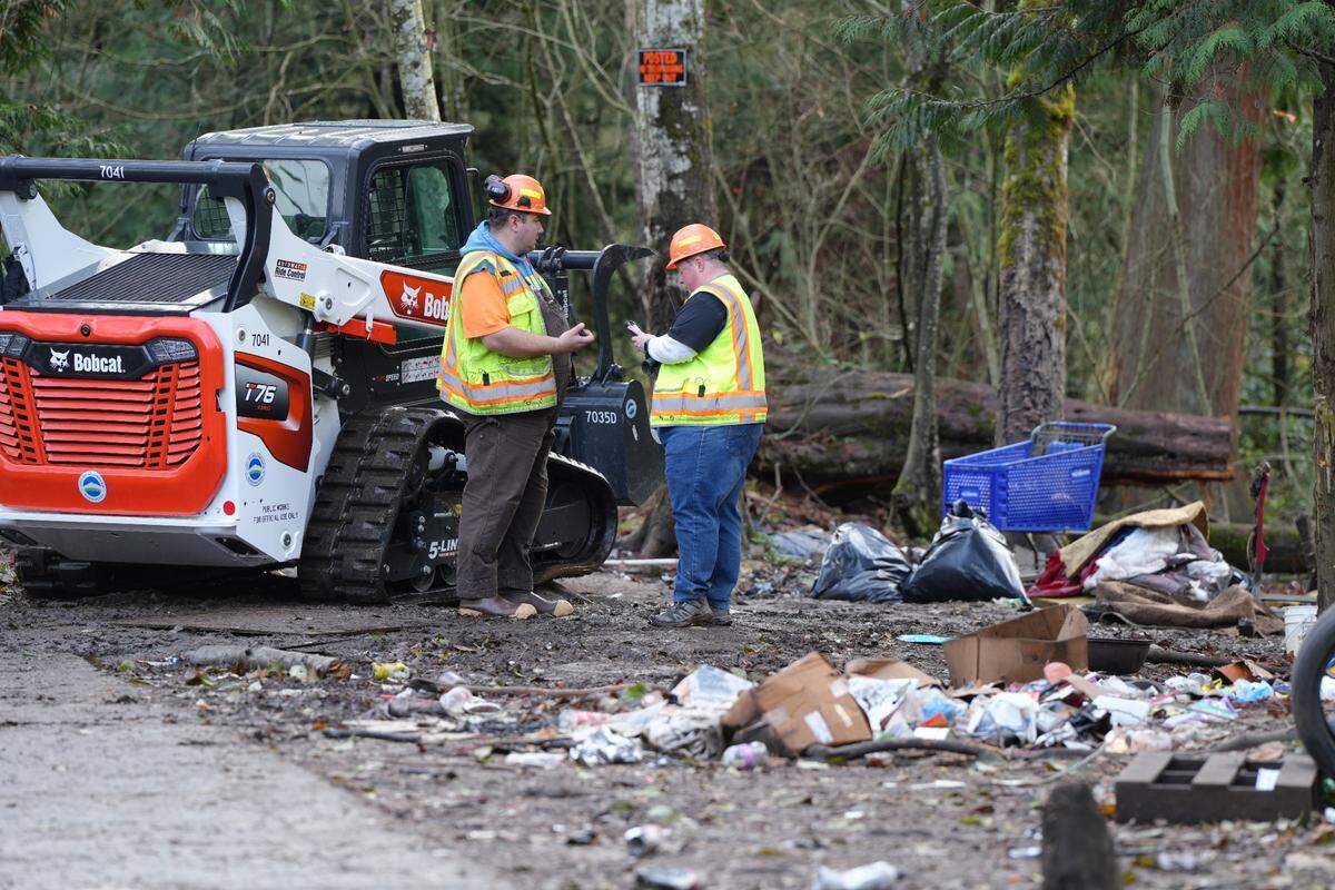 City crews used a Bobcat to clear large items from the encampment behind Walmart as they began cleanup efforts on Nov. 19, 2024, in Bellingham, Wash.