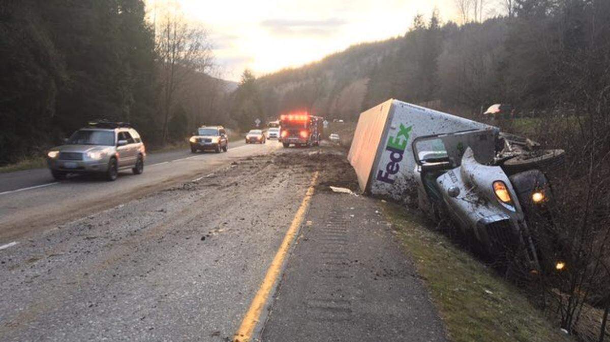 Firefighters block a lane of traffic where a FedEx semi-truck lost control Wednesday evening on a curve near the North Lake Samish exit.