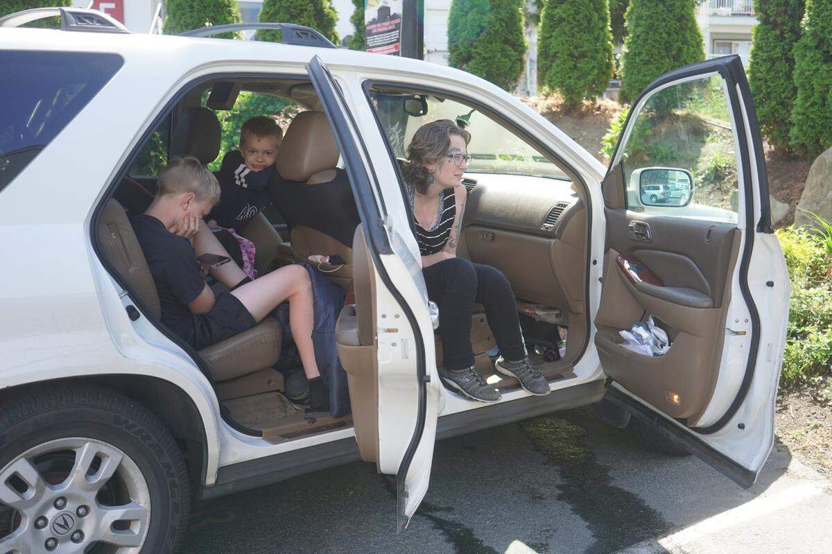 Six children are living with their mother, Cassandra, and father, David, in their family vehicle on July 27, 2023, in Bellingham, Wash. David works nearby while the family sits in the car with the air conditioning running to stay comfortable.