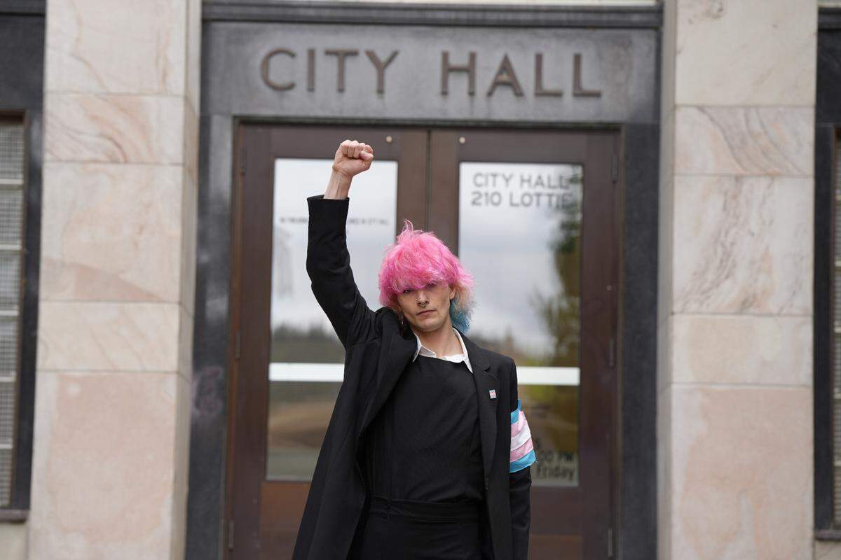 Local transgender rights activist Selene Etheridge holds up a fist in front of City Hall on June 4 in Bellingham.