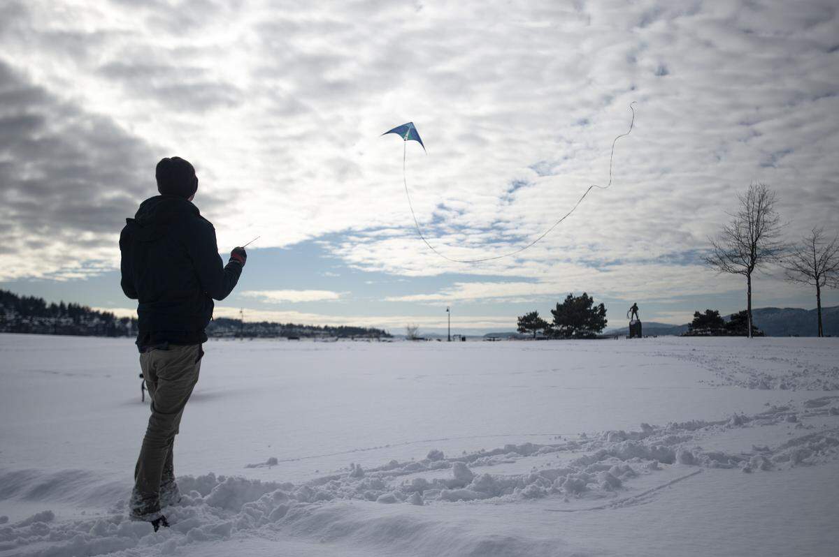 Noah Kaplan flies a stunt kite, or dual-line kite at Zuanich Point Park on Wednesday in Bellingham. Kaplan, who’s never flown the kite in the snow before said, “It’s incredible, although I might wear warmer socks next time.”