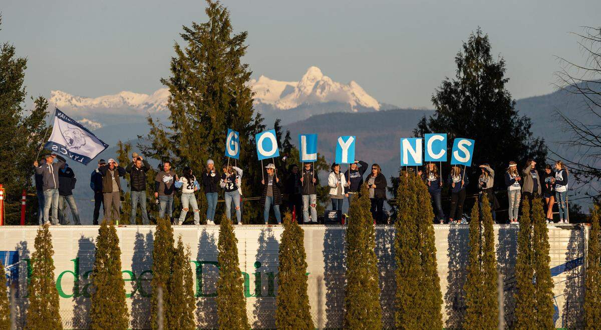 Lynden Christian fans watch from the top of a semi-trailer as the Lynden Lions and Lynden Christian Lyncs battle on the gridiron during their first meet in more than 30 years on Tuesday evening March 16 at Lynden High School. With COVID-19 regulations limiting the number of spectators in the venue, many fans crowded the fence line to cheer their team. The Lyncs defeated the Lions 28 to 21 making them undefeated in conference games.