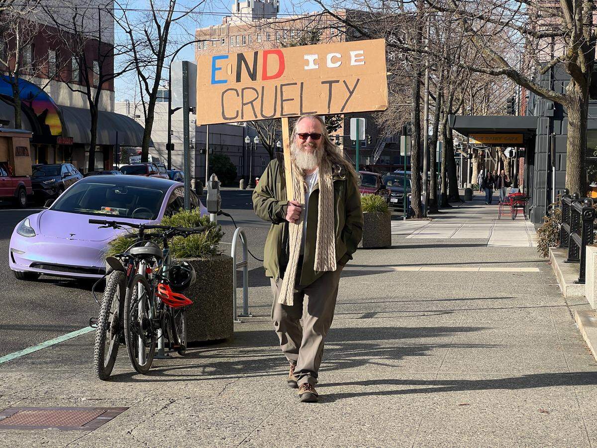 Jason Hart of Bellingham carries a sign that says “End ICE Cruelty” during a rally at the Federal Building in downtown Bellingham on Sunday.