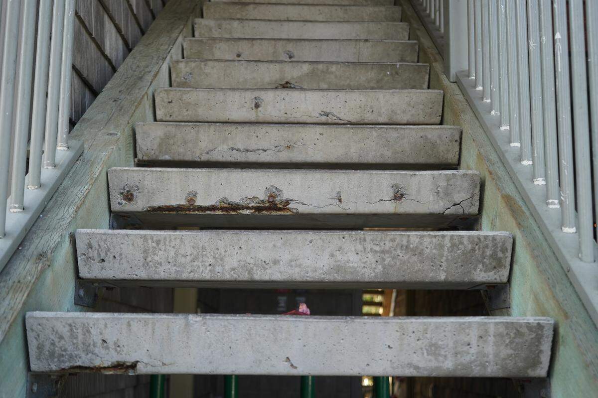 A staircase is degrading at the Meadow Wood Townhomes on Sept. 22, in Bellingham, Washington. Multiple steps show exposed rebar where the cement has been chipped away.
