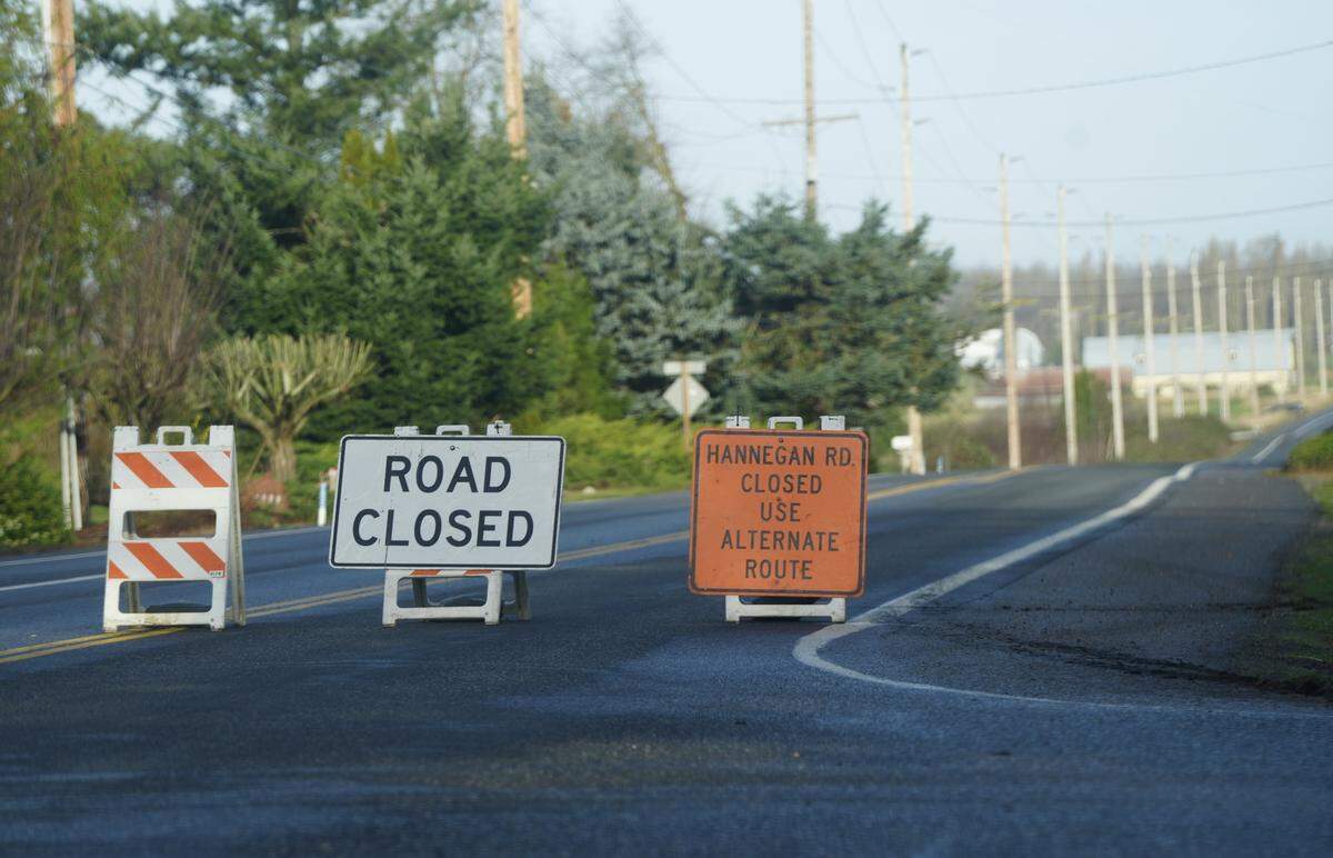 Signs indicate the closure of Hannegan Road between Lynden city limits and Polinder Road on December 9, 2025, due to flooding over the roadway in Whatcom County, Wash.