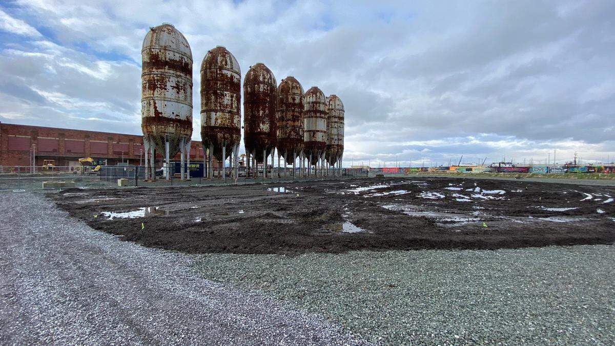 Topsoil is laid down in preparation for grass to be planted on the Bellingham waterfront in 2020. The Boardmill building, left, and six digester tanks remain on the property from the time when it was the Georgia-Pacific pulp and paper mill.