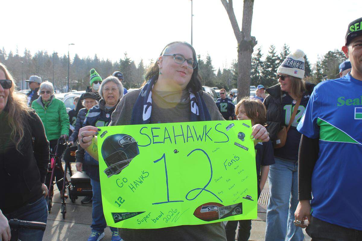 Julyanna Wriggly poses with her sign for the 12th Man rally at Civic Stadium on Friday.