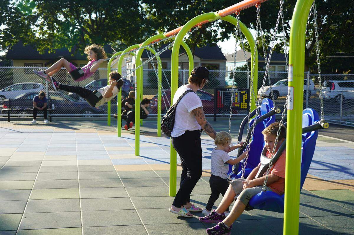 Children play on the adaptive swings at the inclusive playground at Sunnyland Elementary School at an open house event in 2022 in Bellingham. Silver Beach Elementary School will get a similar inclusive playground this summer.