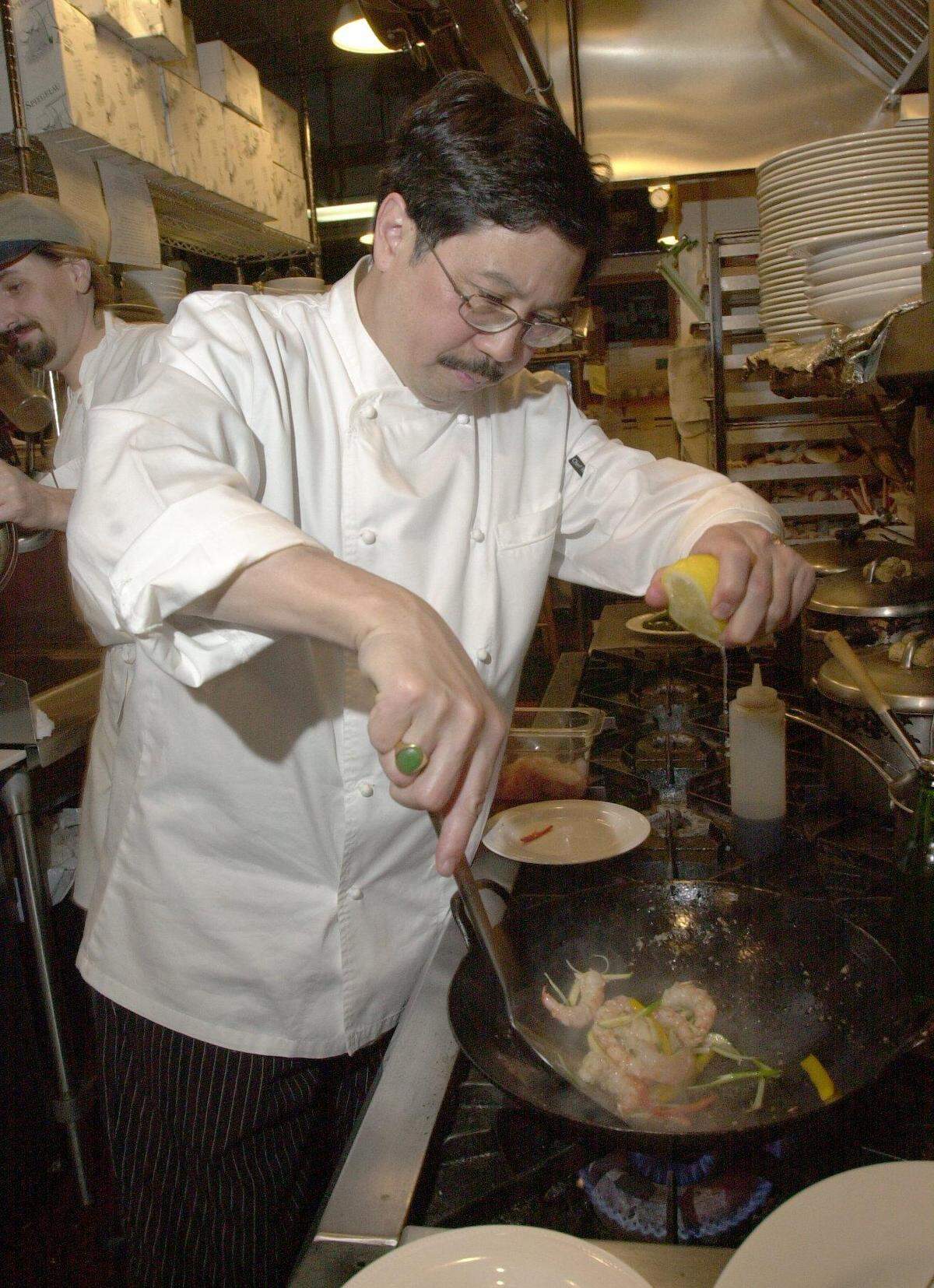 Chef Robert Fong cooks chili prawns at his restaurant, the Pacific Cafe, next to Mt. Baker Theatre in downtown, Bellingham, Wash., in 2002. He closed the restaurant in 2007.