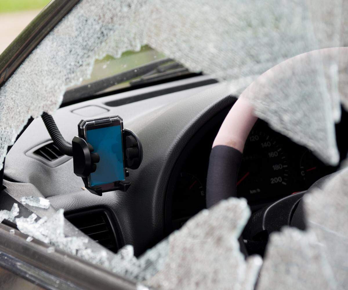 A car window is smashed and the navigational system is stolen. Only the empty cradle is left. Focus is on the cradle