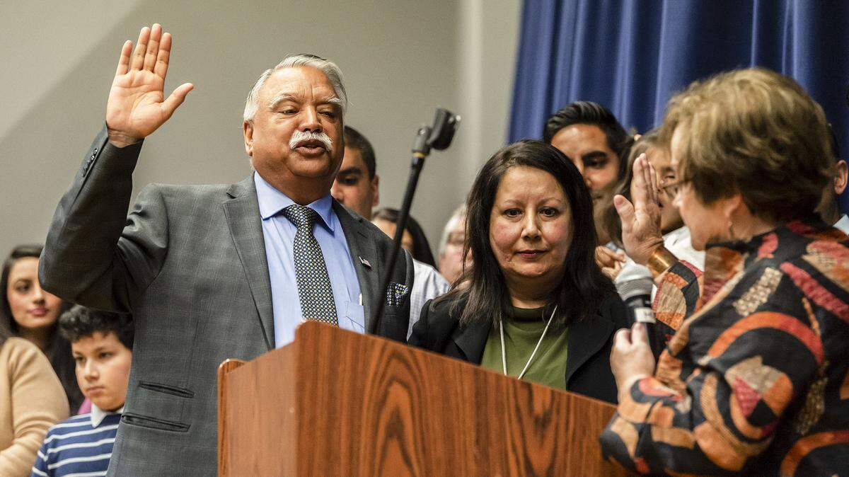 Whatcom County Executive-elect Satpal Sidhu, right, takes the oath of office from out-going Whatcom County Auditor Debbie Adelstein, right, as his wife Mundir Sidhu observes during his swearing-in ceremony on Saturday, Jan. 11, 2020, at Meridian High School in Laurel, Washington.