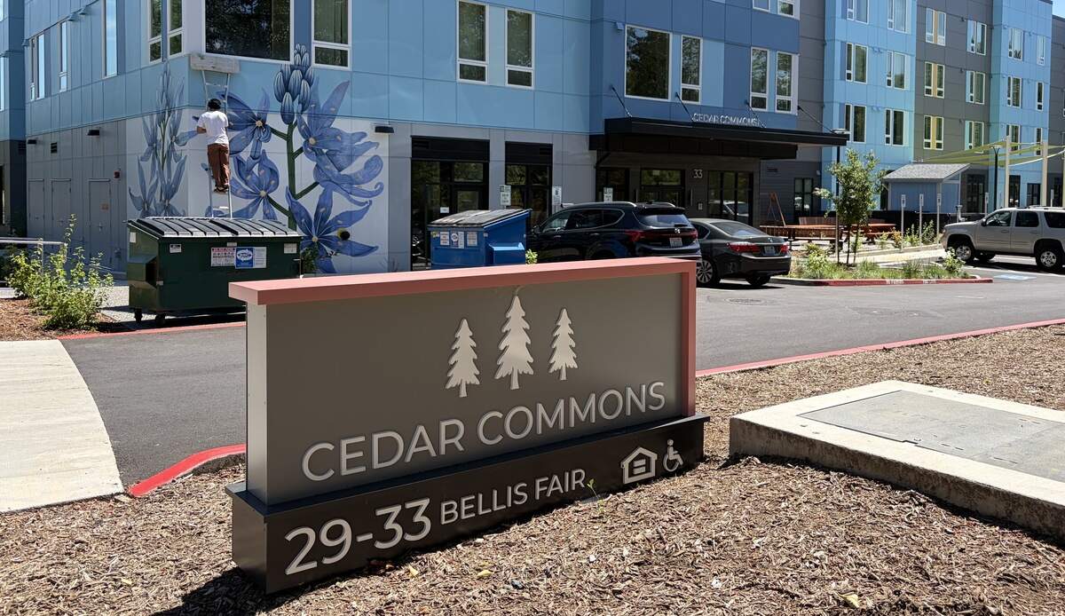 An artist painted a mural at the Cedar Commons affordable housing complex last week. The second phase of the project is still under construction.