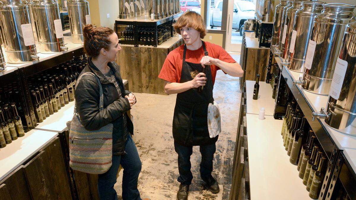 Customer Christie Dukue is helped by Austin Bach at the Drizzle tasting room in Lynden in 2015. The store, which sells premium olive oils, vinegars and spices, is closing Oct. 20 so its owner can concentrate on the flagship store in Fairhaven.
