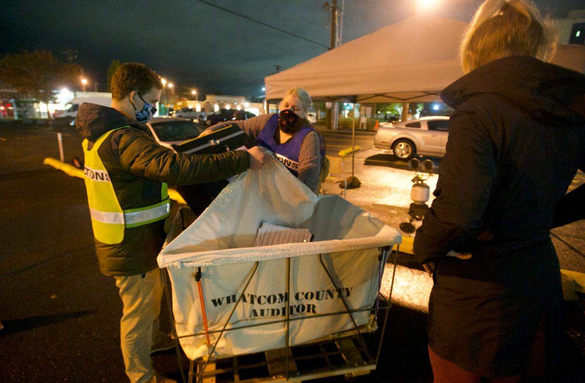 Elections volunteers remove ballots from an official dropbox at 8 p.m. on Tuesday, Nov. 3, in Bellingham.