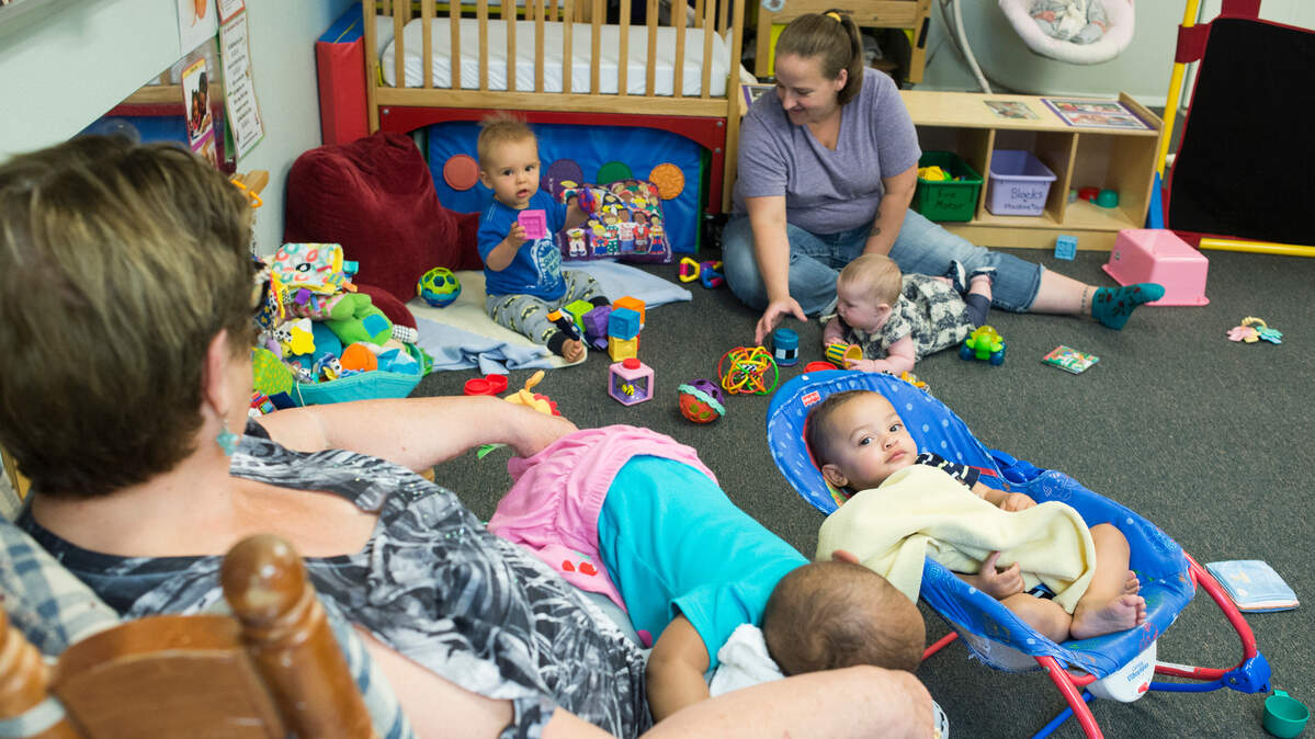 Barb Steele, left, and Tera Herting, lead infant teachers, watch infants play and nap at Promise Day Care near Bellingham. Parents often have trouble finding child care, especially for infants and toddlers. “Families are really struggling to find quality care, and be able to work,” says Kim Walbeck, director of Promise Day Care.