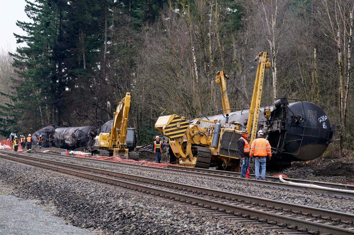 Workers use heavy equipment to begin to move one of several train cars which had been hauling crude oil and derailed a week earlier in December 2020, in Custer. In its report released Thursday, June 10, the National Transportation Safety Board did not determine the cause of the incident, but the FBI is now in charge of an inquiry.