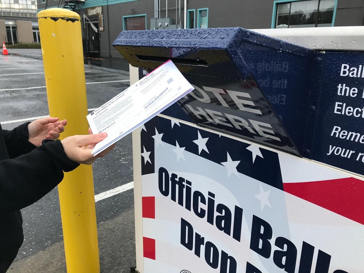A voter users a dropbox for ballots near the Whatcom County Courthouse in Bellingham on Sunday, Oct. 18.